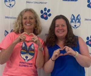 Principal Claire Peters and Asst. Principal Kathryn White Mallik making heart-hands